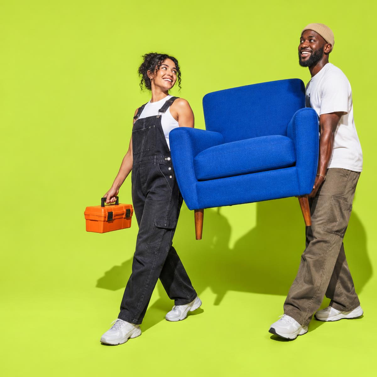 Two neighbors carrying a blue chair together